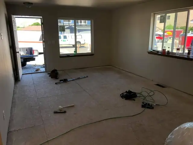 Room with new windows and a bare subfloor, ready for new flooring